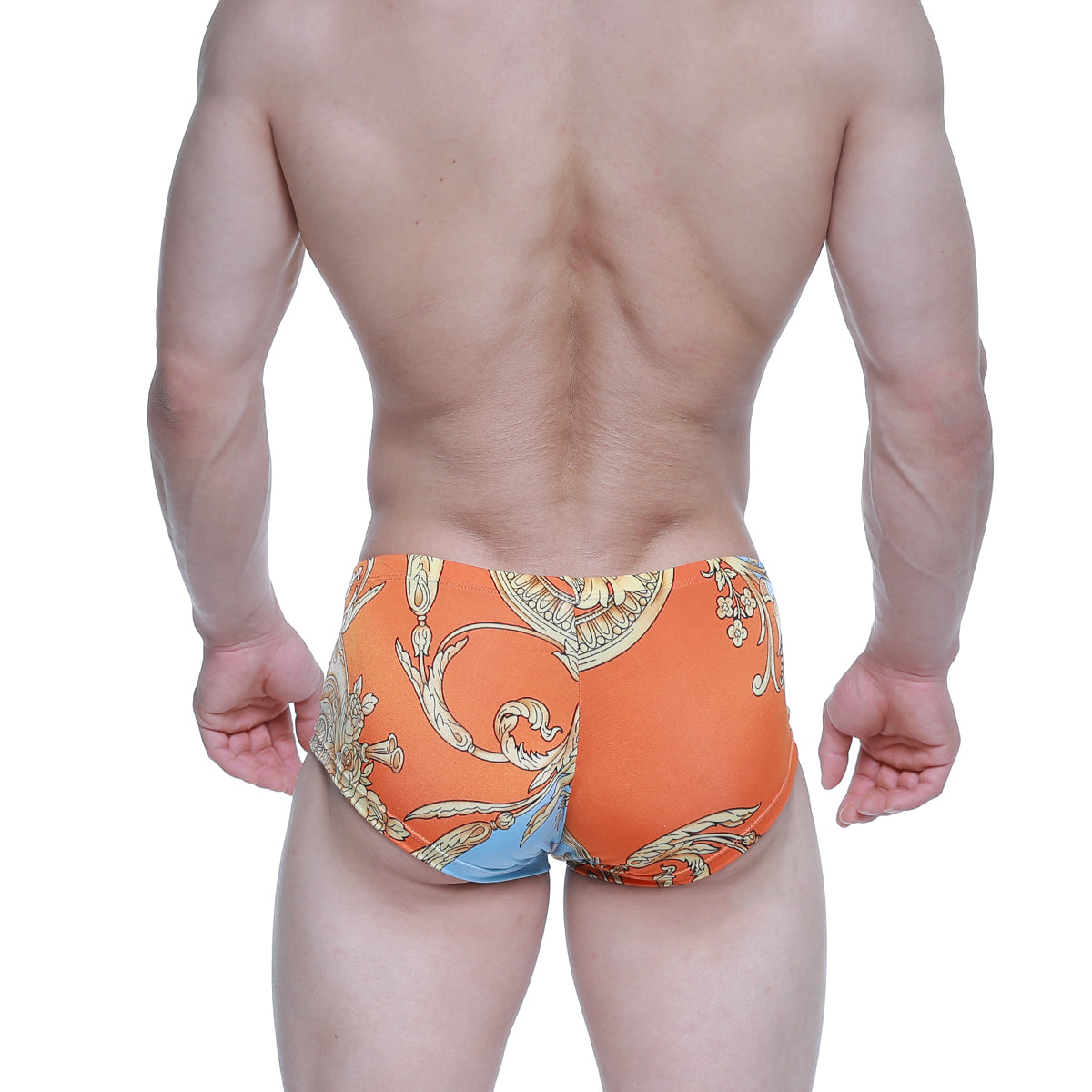 Orange swim trunks by Metromalewear with gold and blue ornate baroque pattern for stylish beachwear