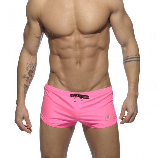 Basic mini short bright pink swim trunks with black drawstring and small logo on lower right leg for swimming