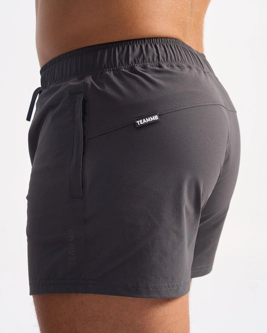 Dark gray lightweight bolt 3 inch athletic shorts with elastic waistband and teammb tag on the back pocket view