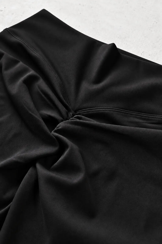 Close-up of black scrunch leggings by JJ Malibu featuring a gathered design at the waistband and soft stretchy fabric