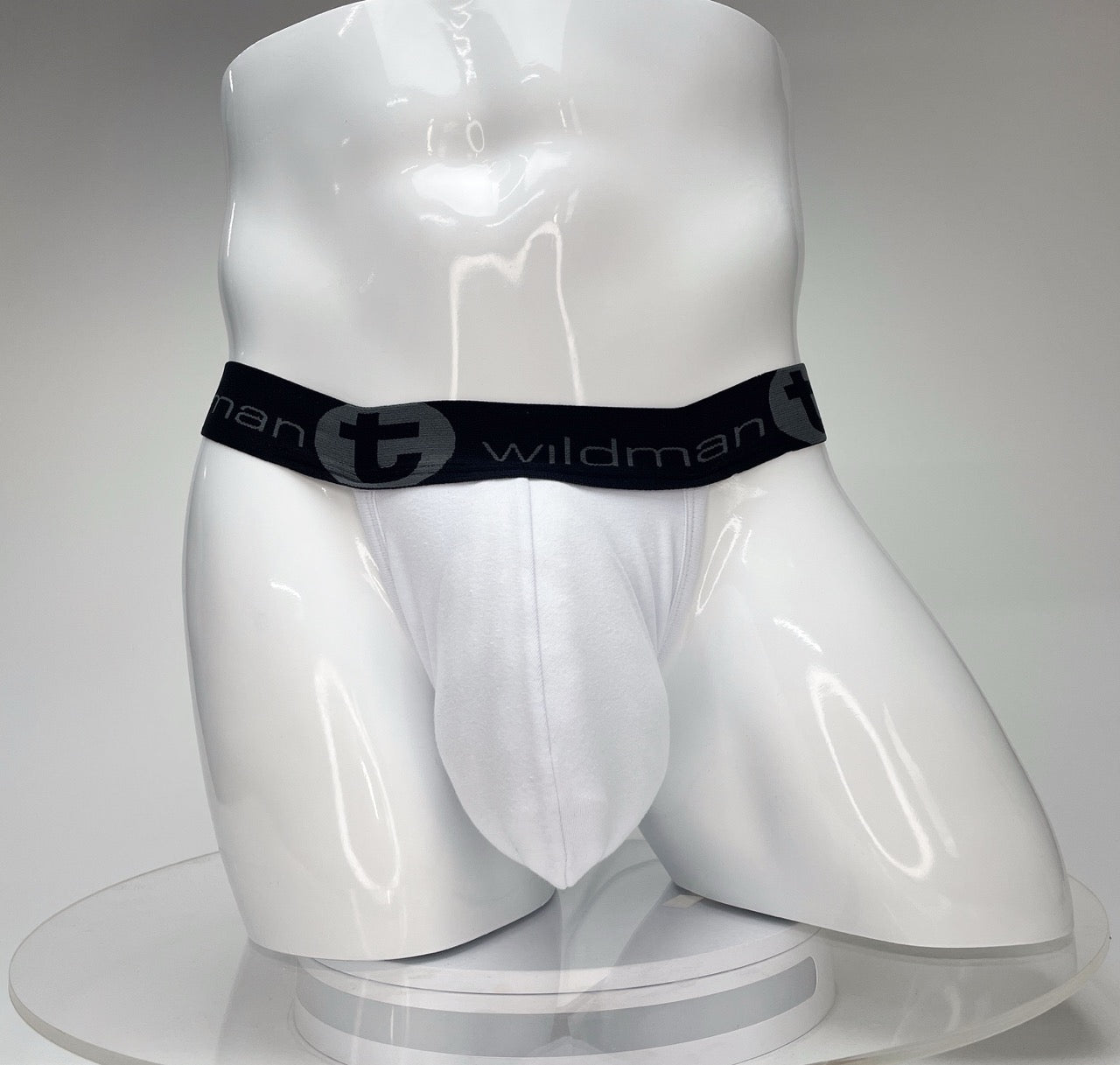 White WildmanT jockstrap with a contoured big-boy pouch and a black branded elastic waistband on a white mannequin.