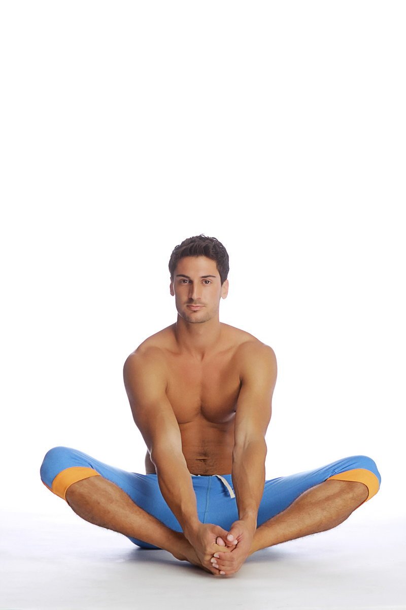 A man wearing cuffed yoga pants in ice blue with orange accents made of breathable athletic fabric