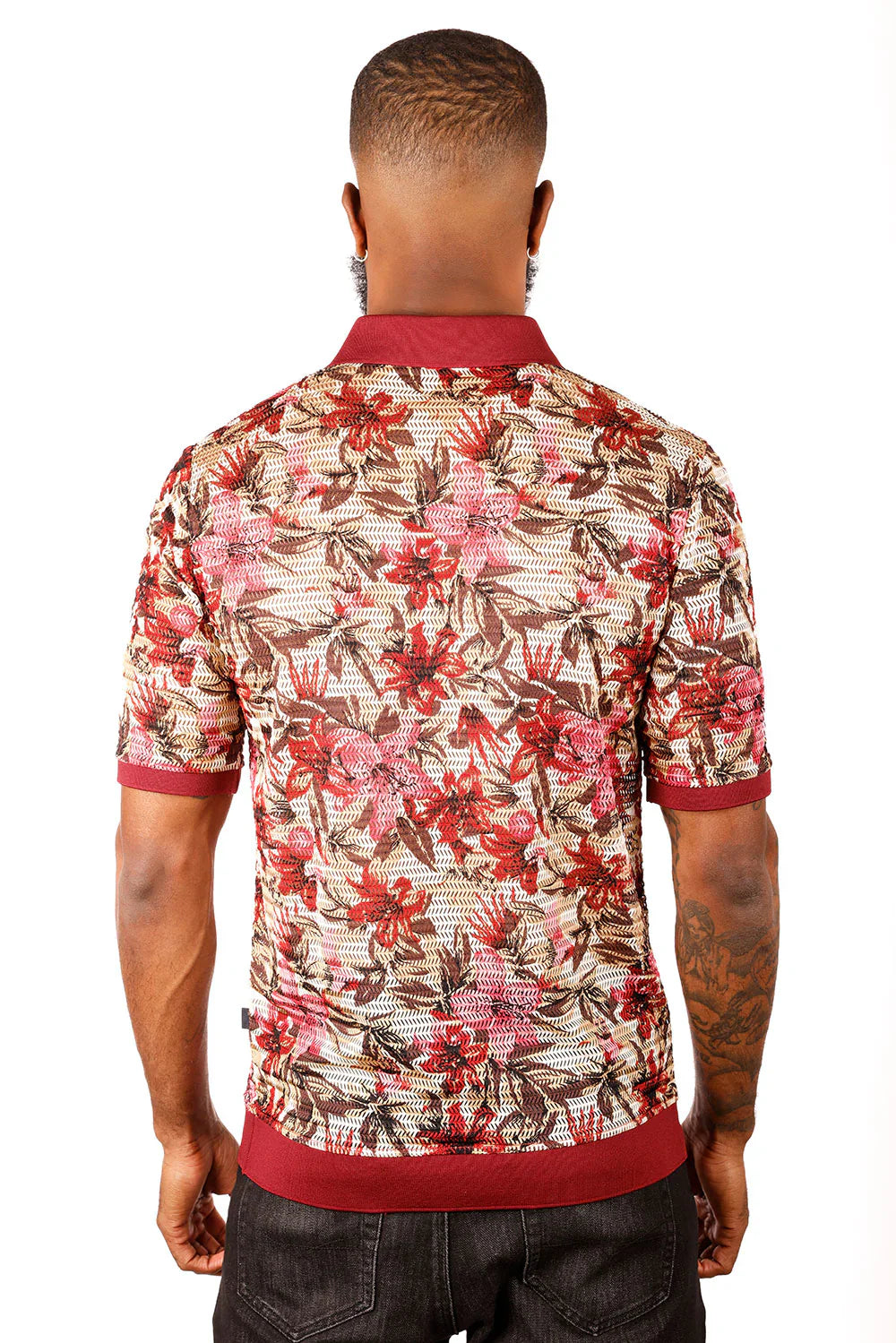 A man wearing an entwine form polo shirt with red pink and brown floral pattern on beige mesh with maroon accents