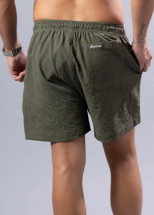 Back view of olive green essential swim short with textured fabric and branded logo on waistband available in 3 colors