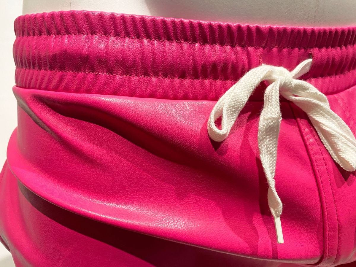 Bright pink faux leather shorts with white drawstring waistband in a style called faux leather short