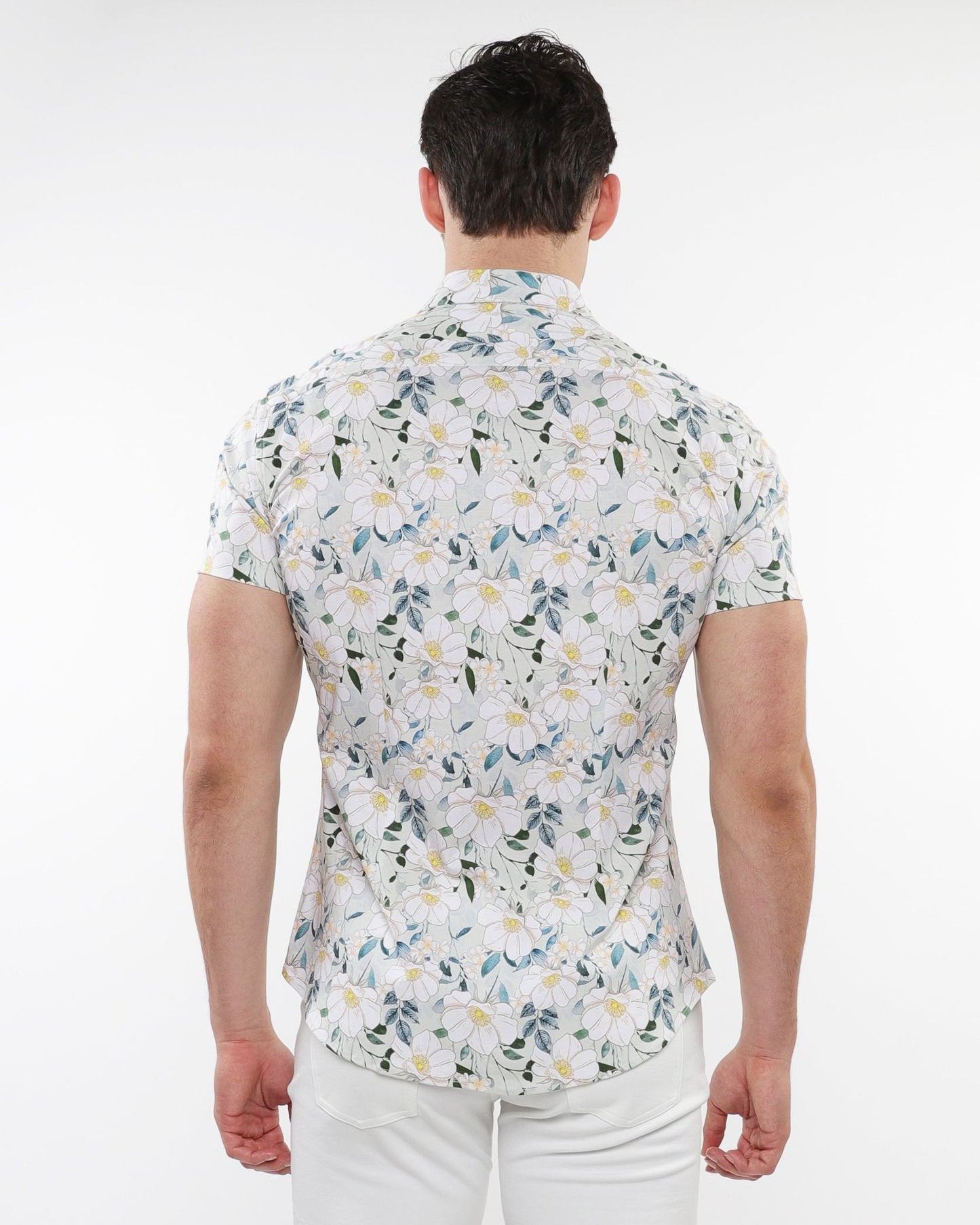 A man wearing a white floral print stretch knit short-sleeved shirt with green blue and yellow pattern