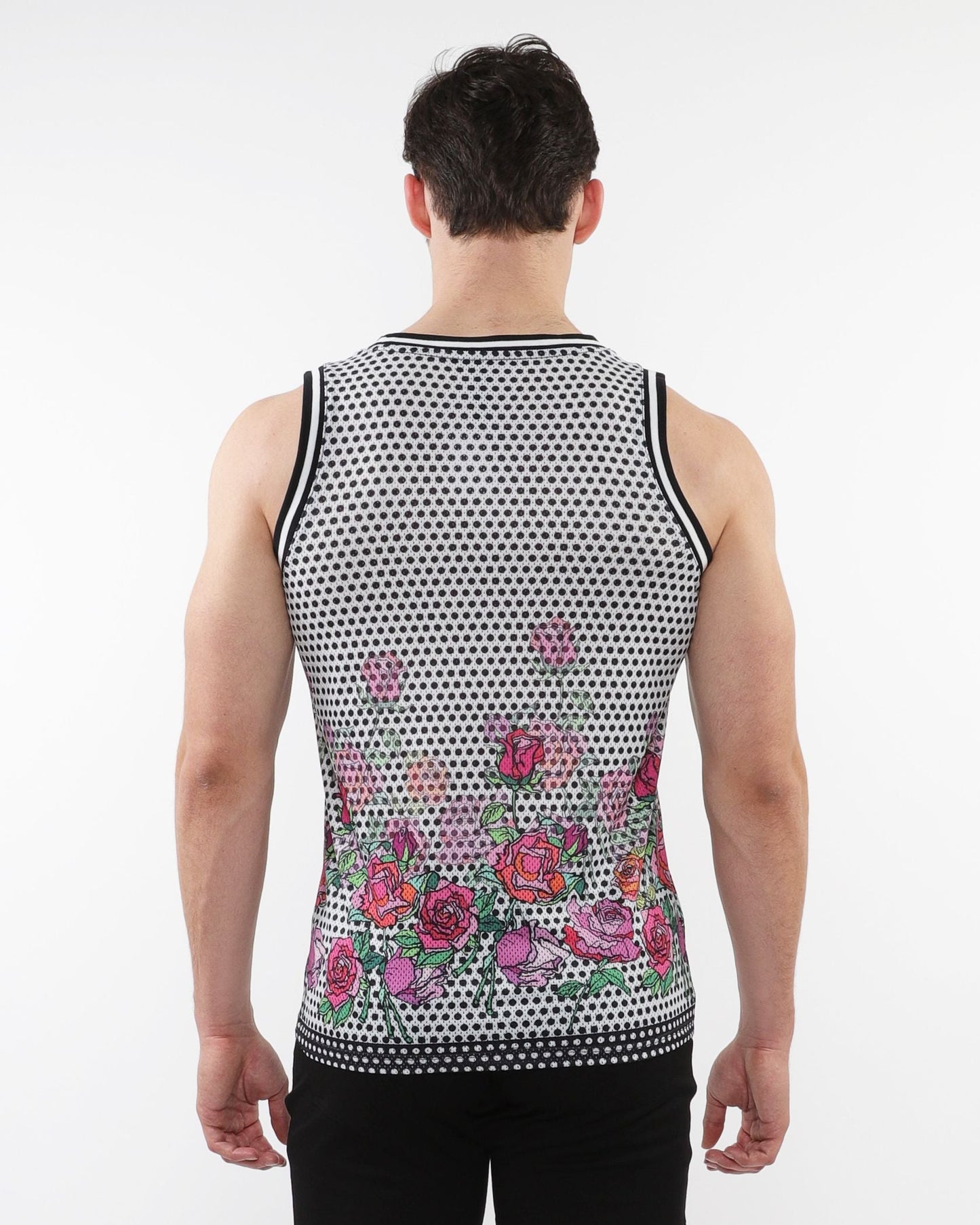 A man wearing a black and white floral printed mesh tank with stripe ribbing and pink roses along the bottom