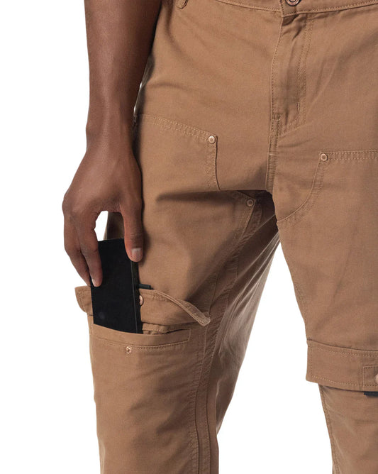 Tan forge pant cargo pants with multiple pockets and button closures designed for durable utility wear