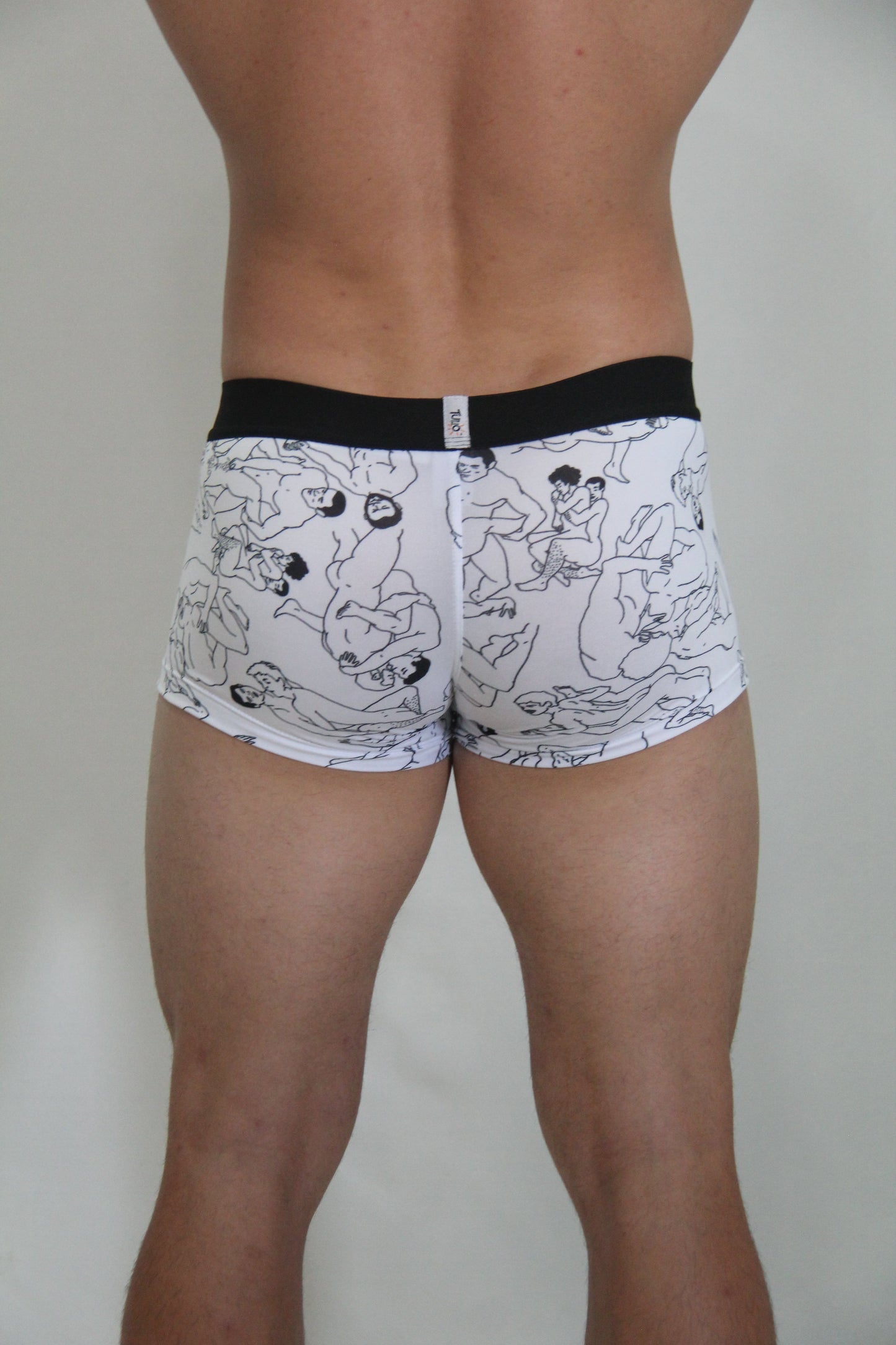 White boxer briefs with black line drawings of figures and a solid black waistband from gay karmasutra trunk collection