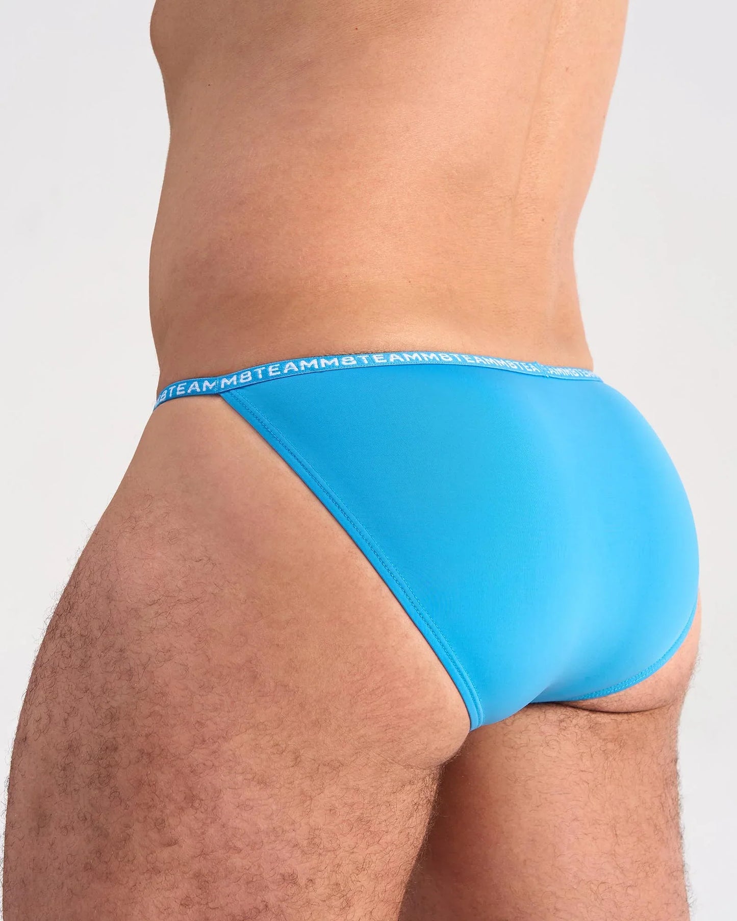 Bright blue glide micro brief with a matching elastic waistband featuring repeating team logo in white