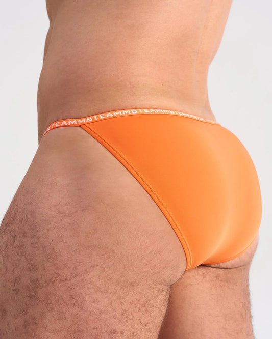 Bright orange glide micro brief with elastic waistband featuring the brand’s repeating logo for comfortable support