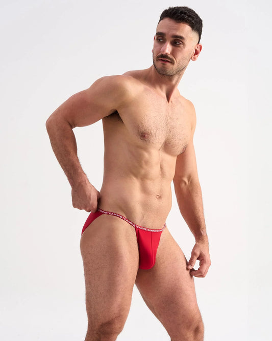 Red mens glide micro brief with thin elastic waistband and white lettering designed for comfortable everyday wear