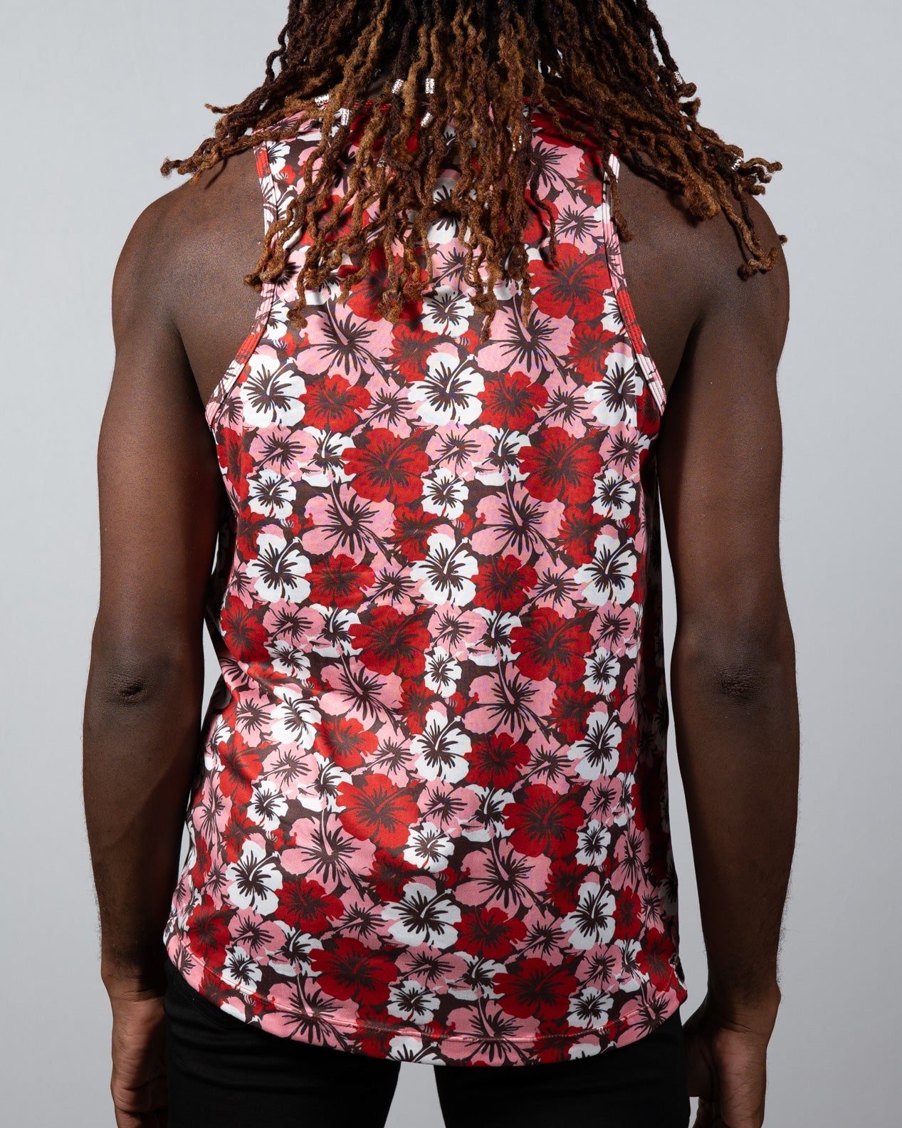 A vibrant red pink and white floral patterned hawaiian hibiscus print tank top with a black background
