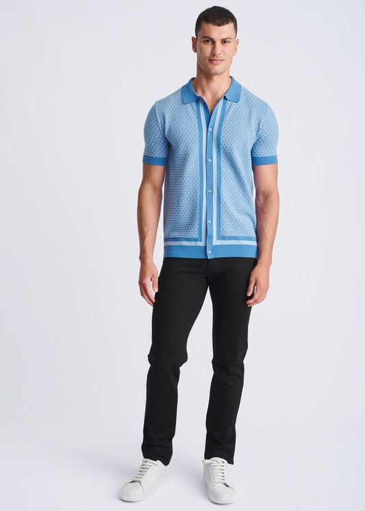 Light blue short-sleeved honeycomb textured knit polo shirt with subtle geometric pattern and dark blue trim