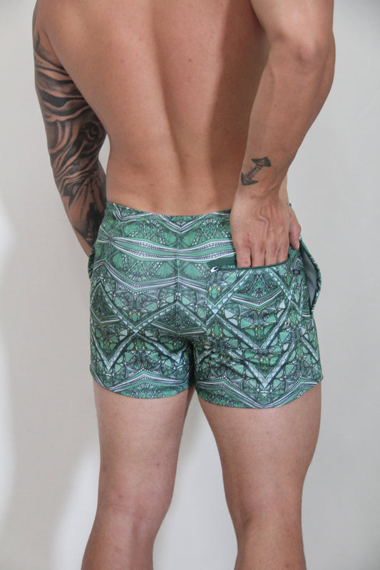 Kaleidoscope shorts green patterned swim trunks with geometric and tribal designs in teal white and dark green
