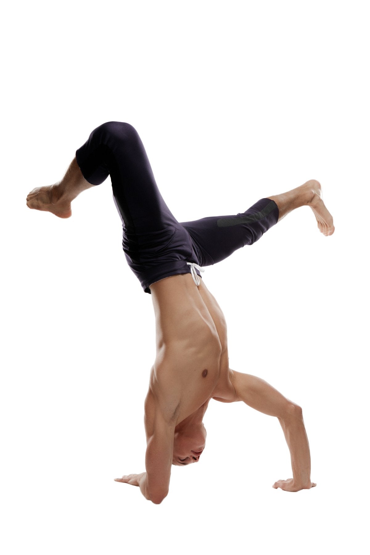 A muscular man performing a handstand wearing black mens 4/5 zipper pocket capri yoga pants designed for flexibility