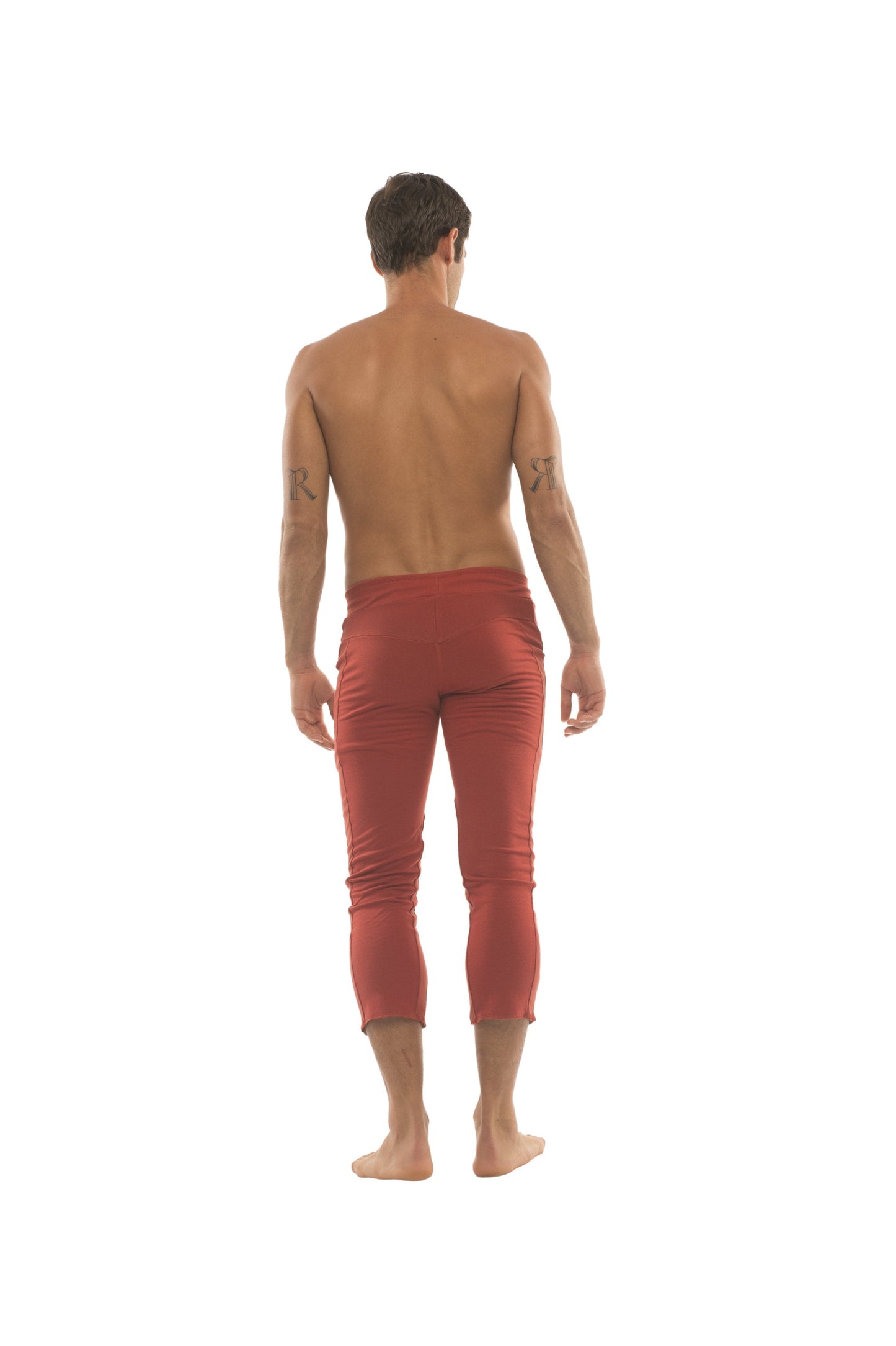 Mens 4/5 zipper pocket capri yoga pants in solid cinnabar red with smooth, slightly reflective rust-red fabric