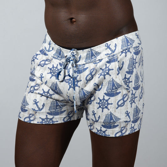 White linen nautical linen texture shorts featuring a blue anchor sailboat and ship wheel pattern on swim trunks