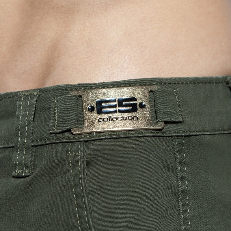 Olive green denim plain cargo short featuring a metallic silver es collection brand plaque with black lettering and rivets