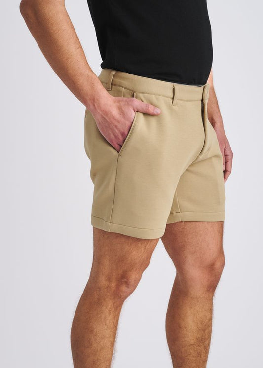 Side view of a person wearing khaki stretch knit chino shorts and a black t-shirt.