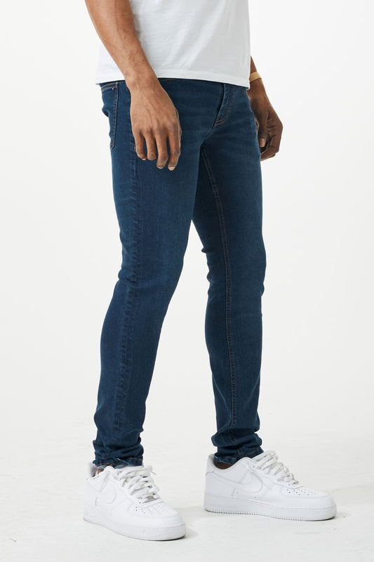Dark blue skinny fit denim jeans with slim fit design, classic five pockets, and subtle thigh fading