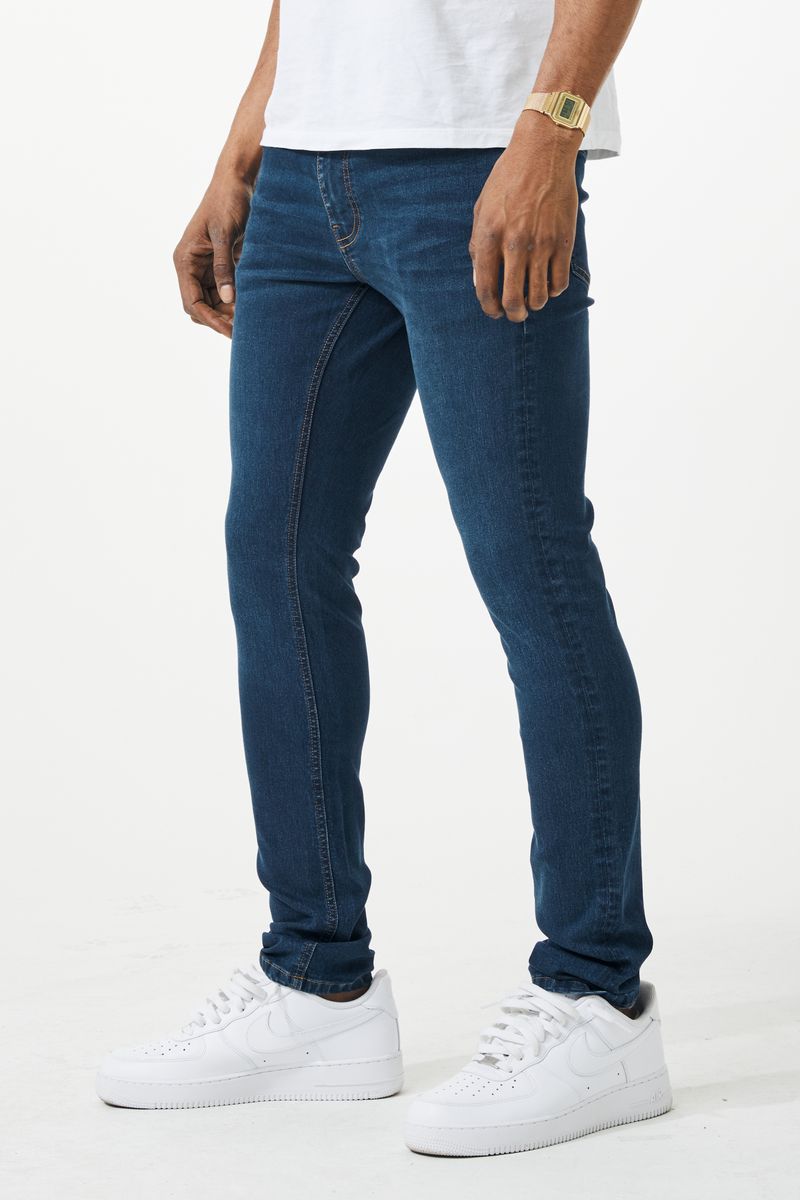 Dark blue skinny fit denim jean with slim fit, five-pocket design, and subtle fading along the thighs