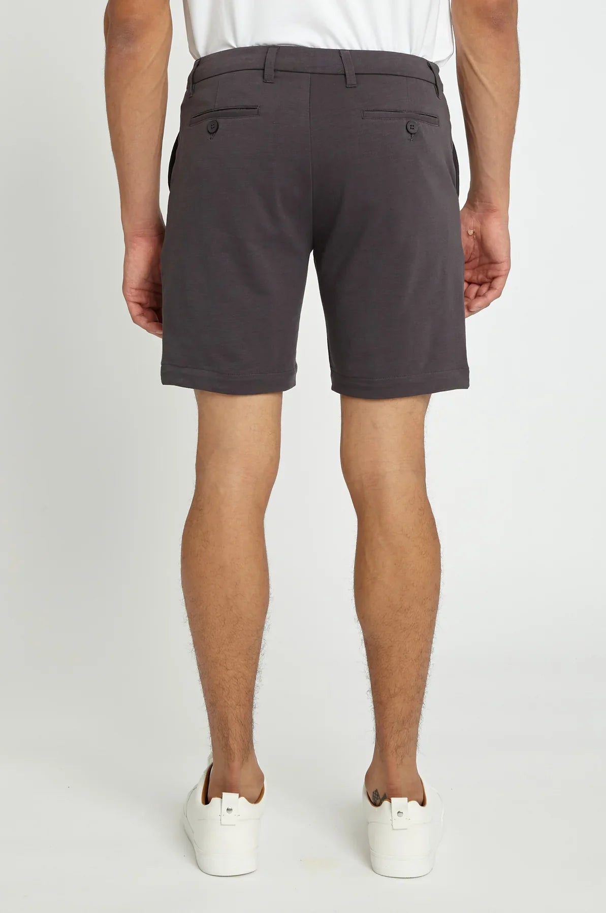 Dark gray solid stretch knit chino shorts with tailored fit and buttoned back pockets shown from the back side