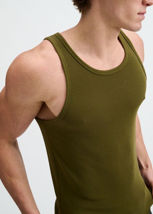 A person wearing a dark olive green ribbed modal tank top, shown from the chest up against a white background.