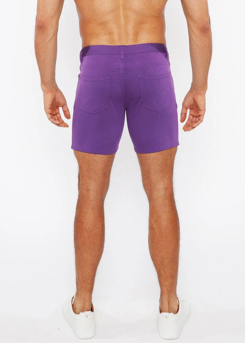 Purple stretch knit shorts with a straight-leg cut and two back pockets shown from the back side