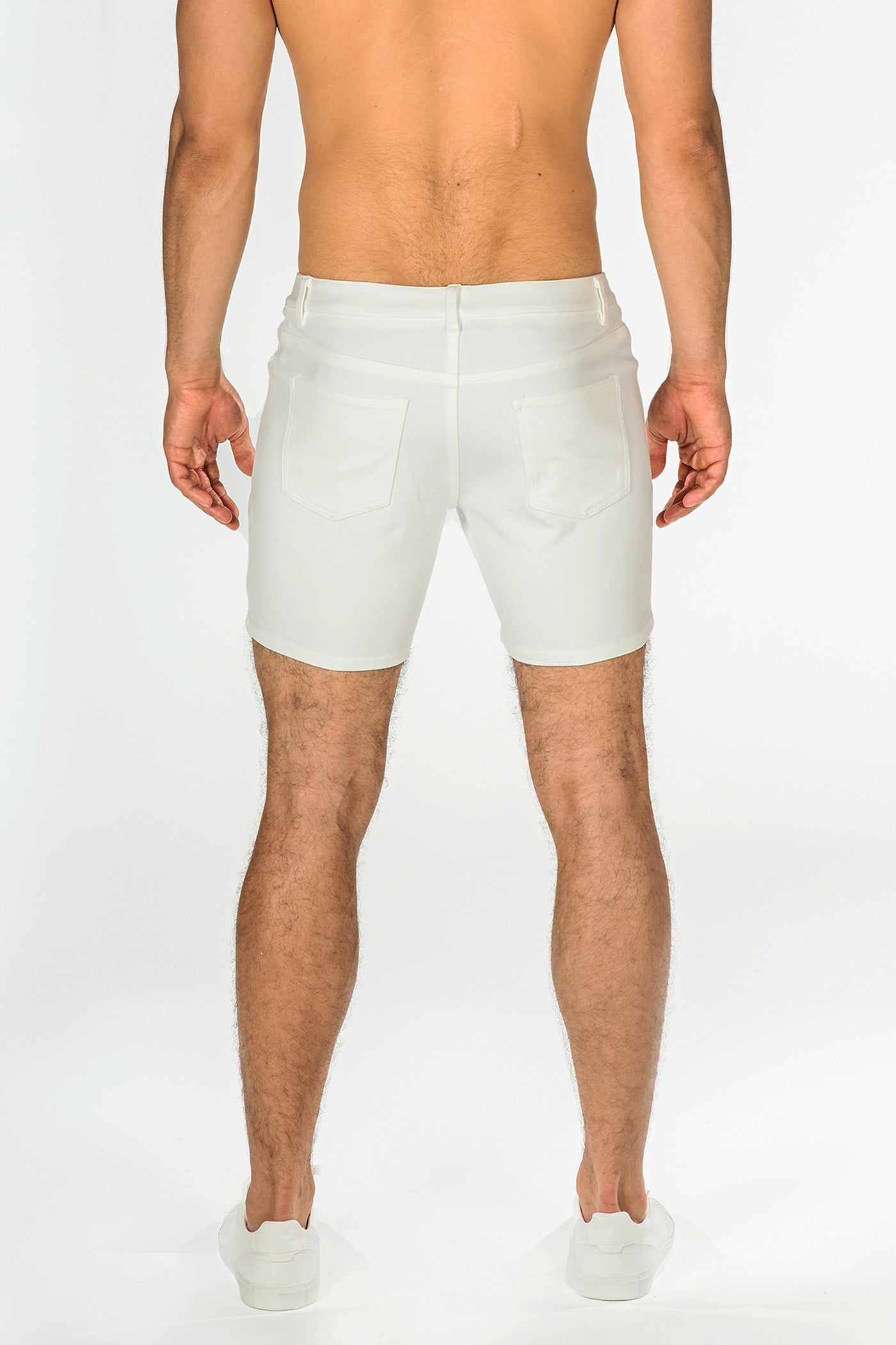 White stretch knit shorts in denim with a tailored fit and classic back pockets shown from the back side