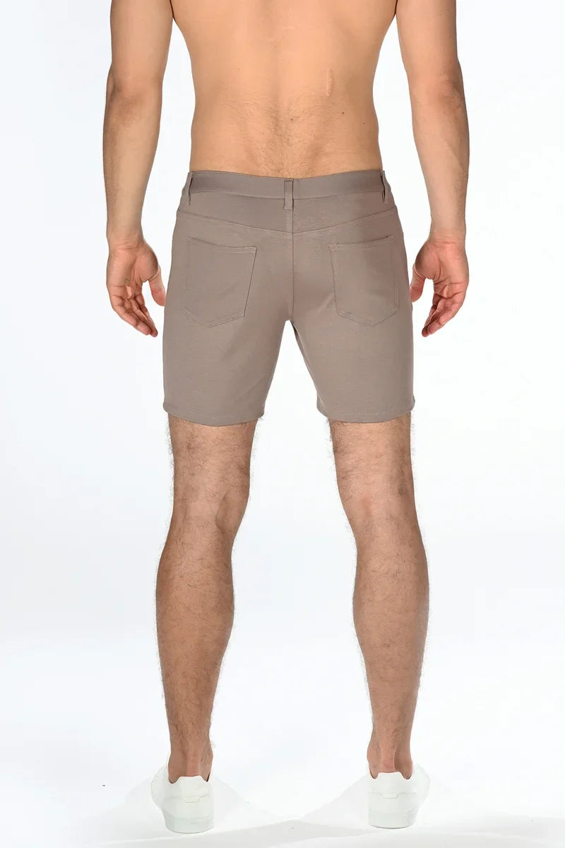 Beige stretch knit shorts with tailored fit and two rear pockets shown from the back side