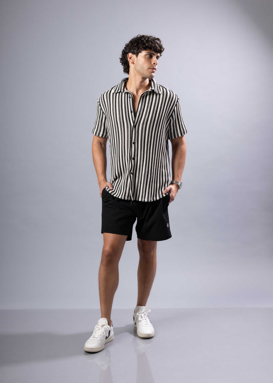 A man wearing a black and white vertically striped texture knit short-sleeved shirt for casual wear