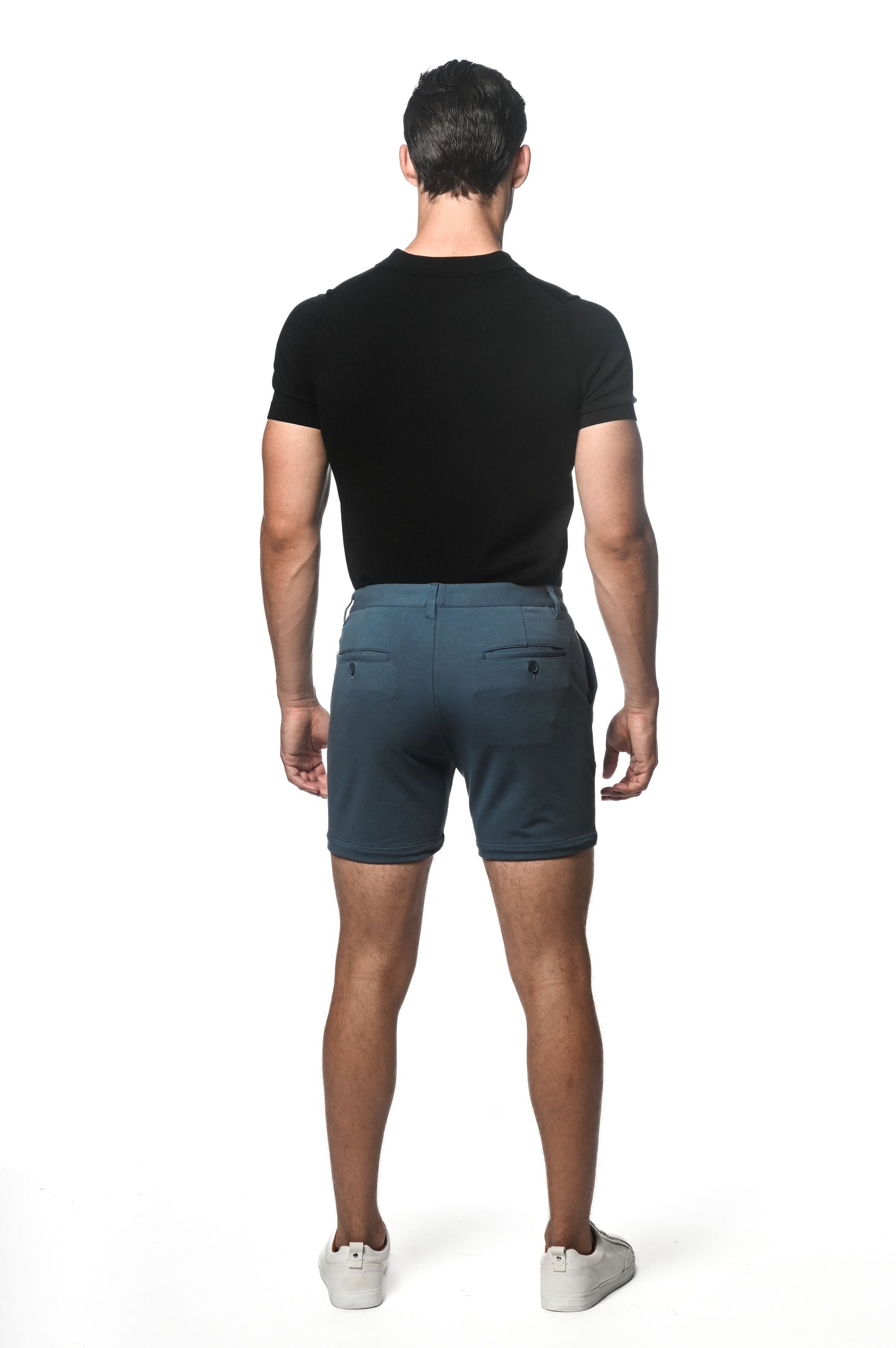 Dark teal textured stretch knit chino shorts with subtle gradient fade and two back pockets shown from the back side