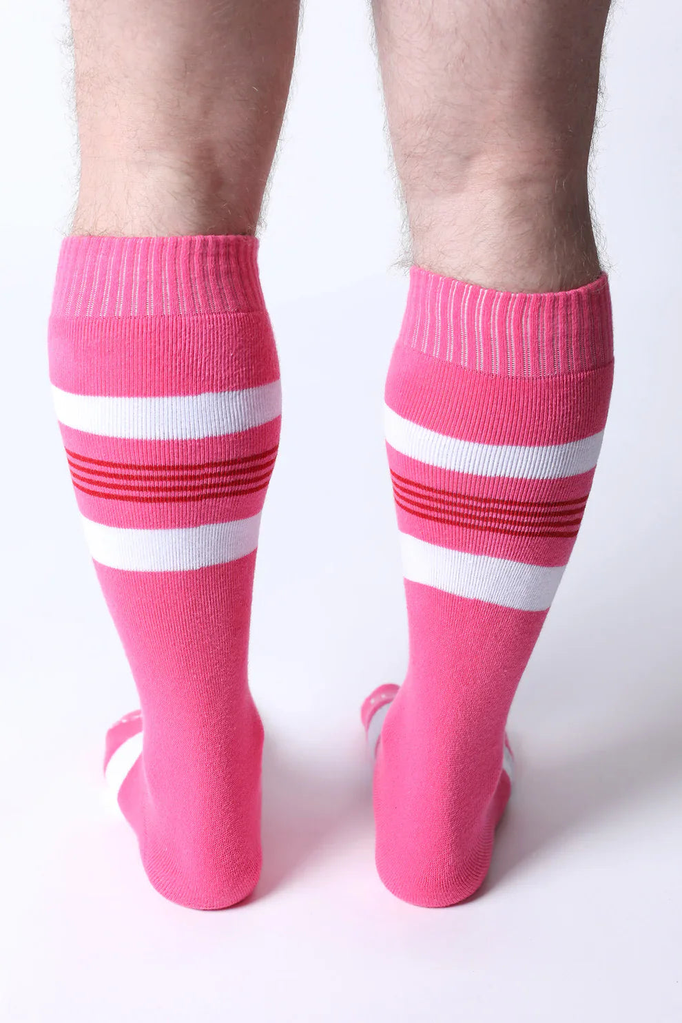 Bright pink tight end knee high socks with white and red striped bands designed for athletic wear