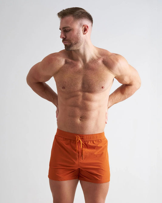 Amber gym shorts with an elastic drawstring waistband, shown on a person against a plain background.