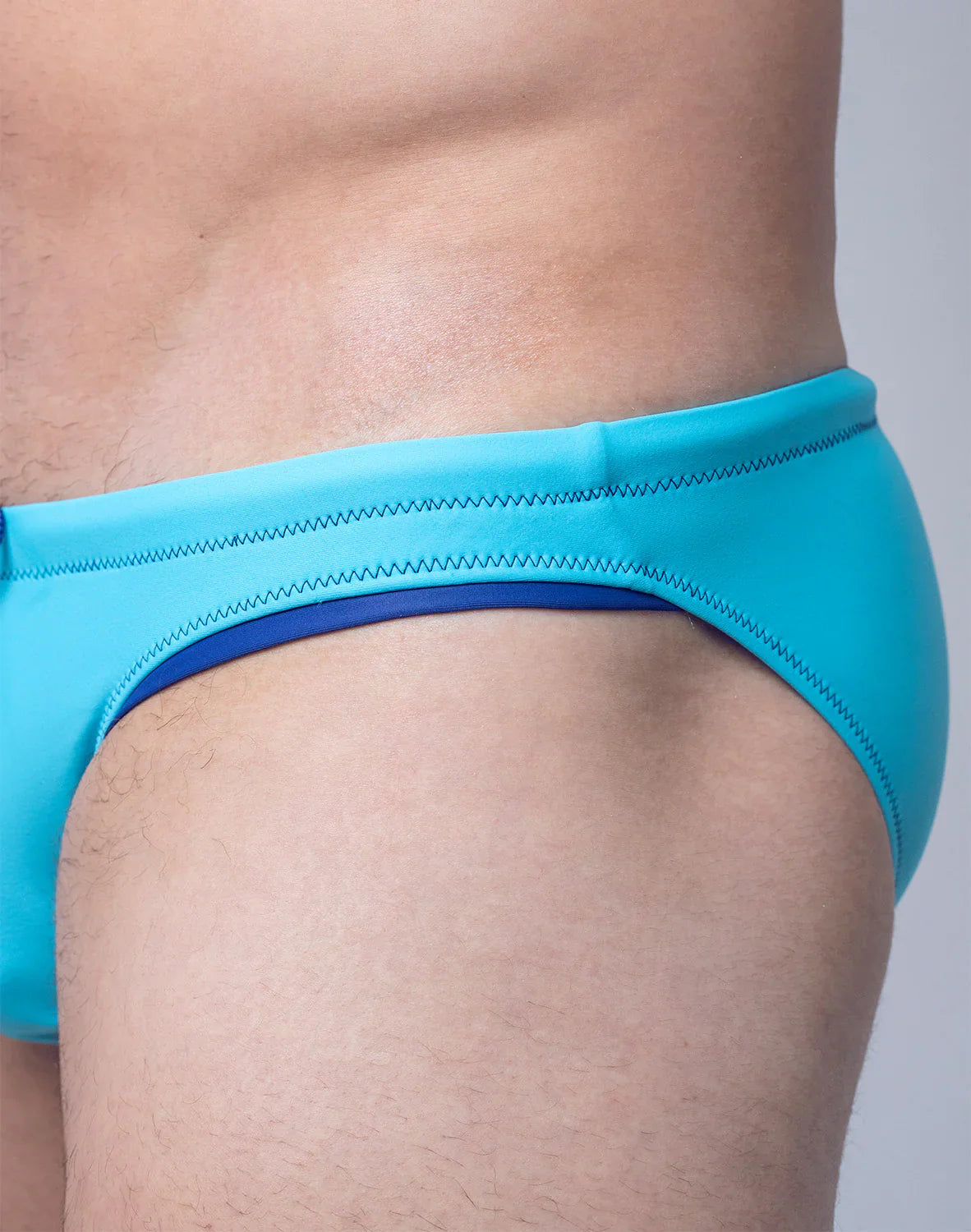 Bright turquoise v22 rapid swim brief with navy blue inner lining and zigzag stitching on the waistband
