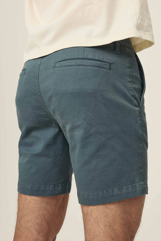 Rear view of dark teal chino shorts with welt pockets and a white t-shirt.