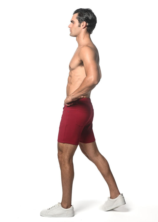 A pair of deep red form-fitting athletic shorts made from washed denim stretch knit fabric worn by a model
