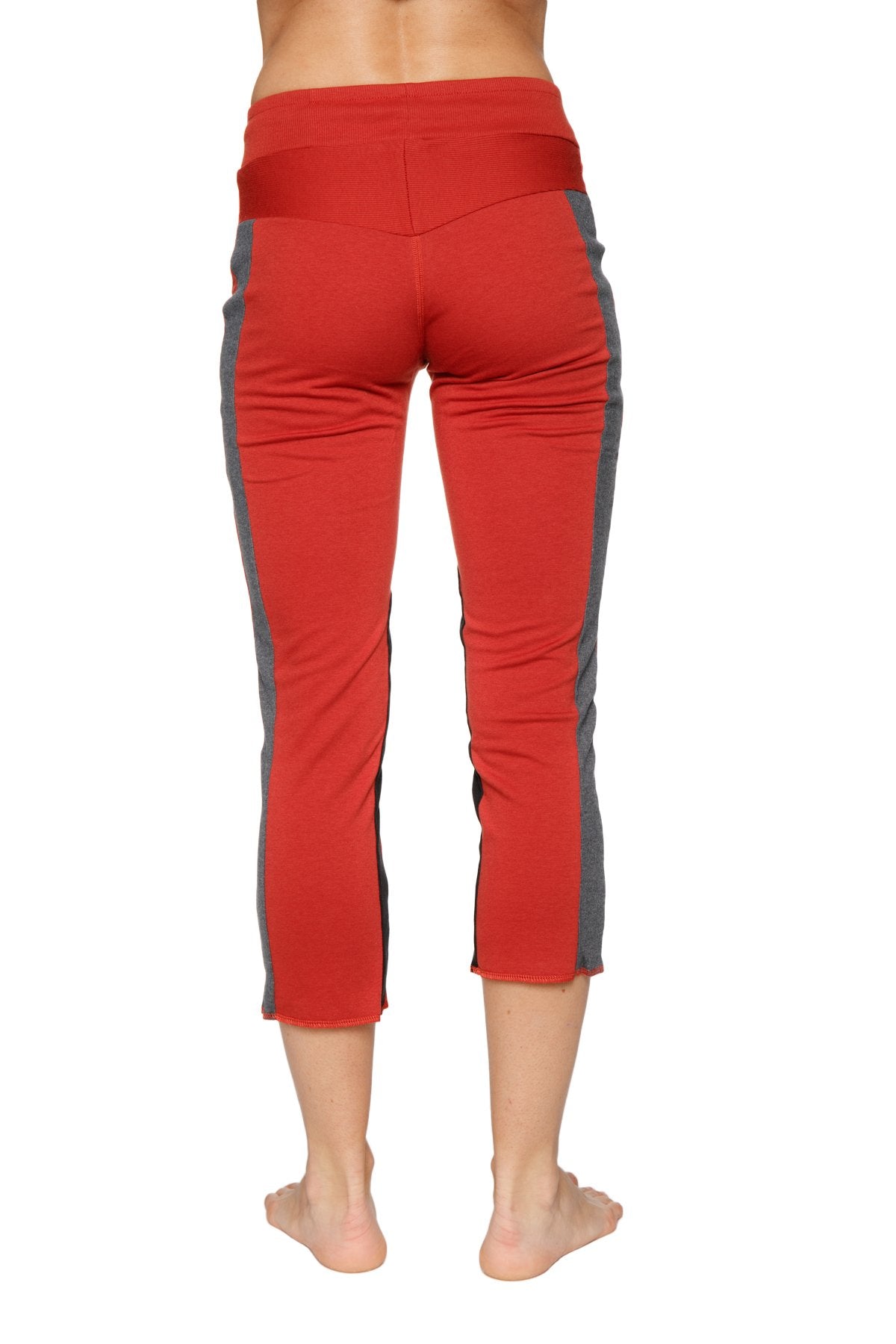 Women’s cinnabar red capri yoga pants with gray side panels high waistband and zipper pockets for active use