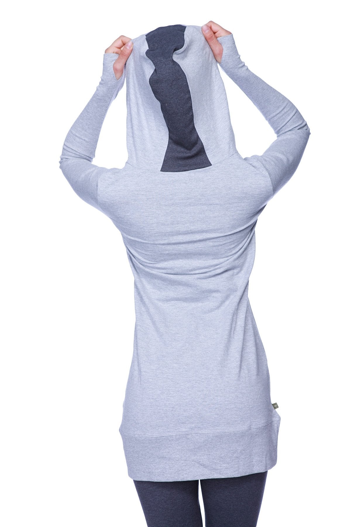 Back view of women’s long body hoodie top in heather grey with charcoal tie-shaped cutout on light gray fabric