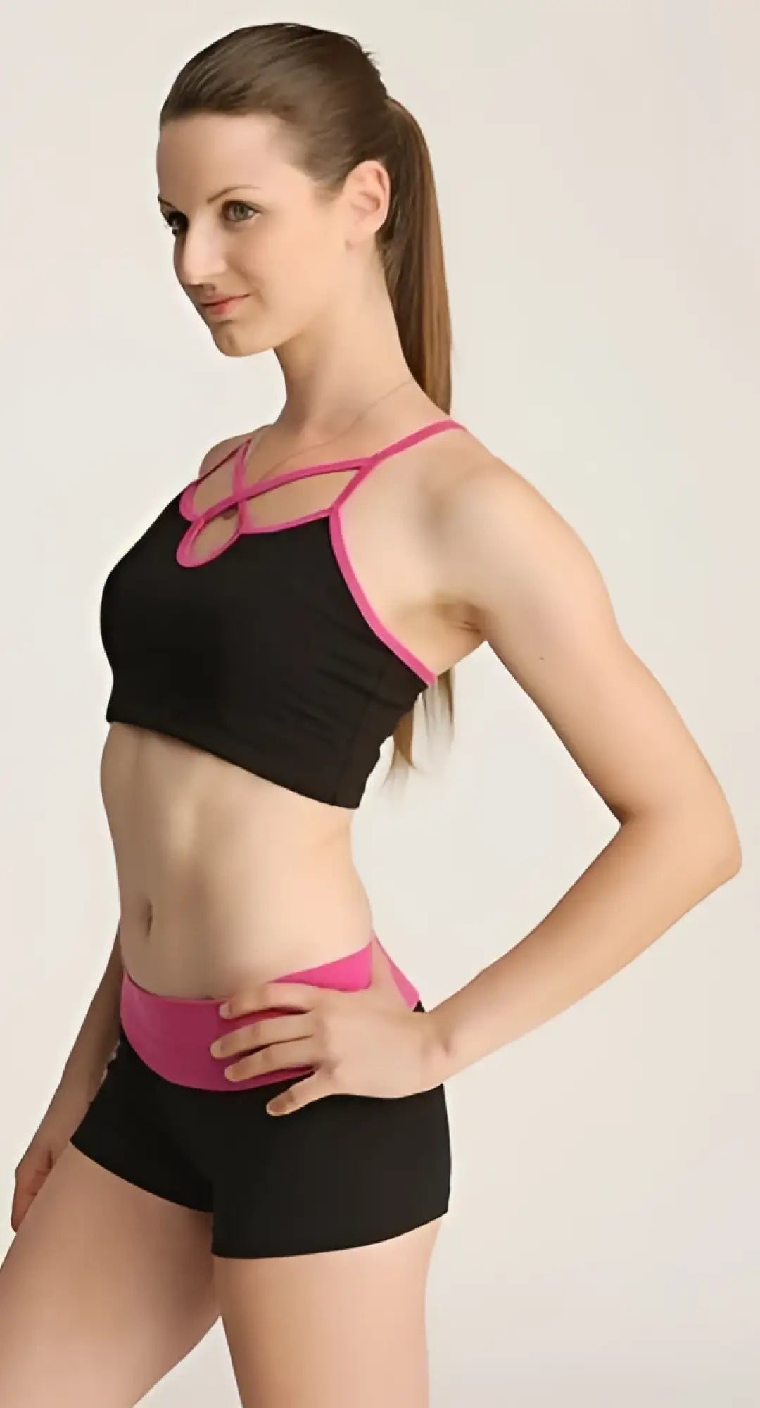 Black and pink bumble short sports bra with crisscross straps and matching waistband for activewear