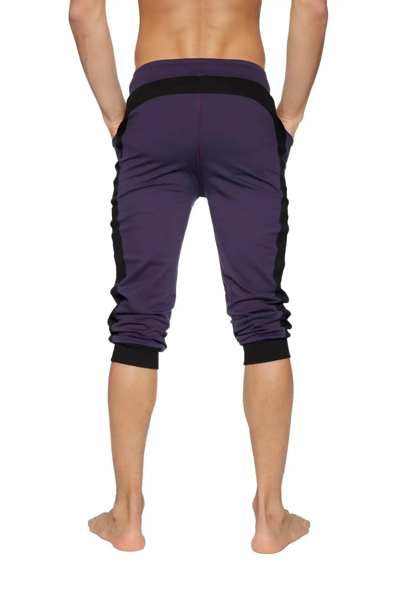 Purple cuffed yoga pants with black side panels and elastic cuffs made from athletic fabric for active wear