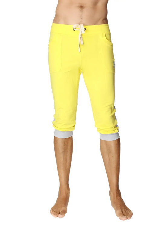 Bright yellow cuffed yoga pants with white drawstring and gray elastic cuffs in capri length for active wear