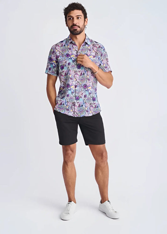 A man wearing a lightweight floral short-sleeved linen tencel shirt in purple, blue, and pink shades