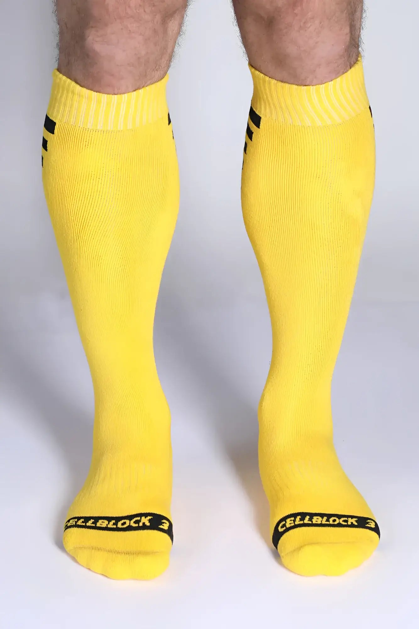 Iron grip knee high socks in bright yellow with black stripes on cuff and cellblock 3 branding at the toe