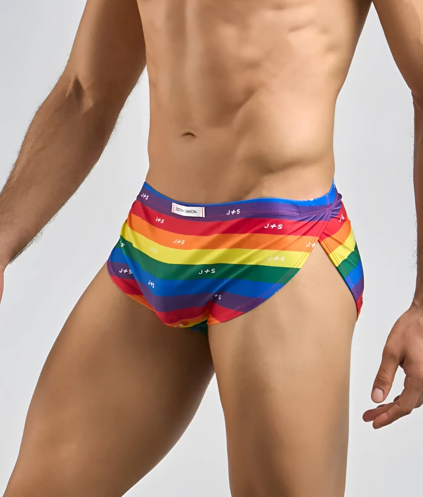 Justin Simon running short men’s swim trunks with rainbow stripes and vibrant multicolored design featuring brand logos
