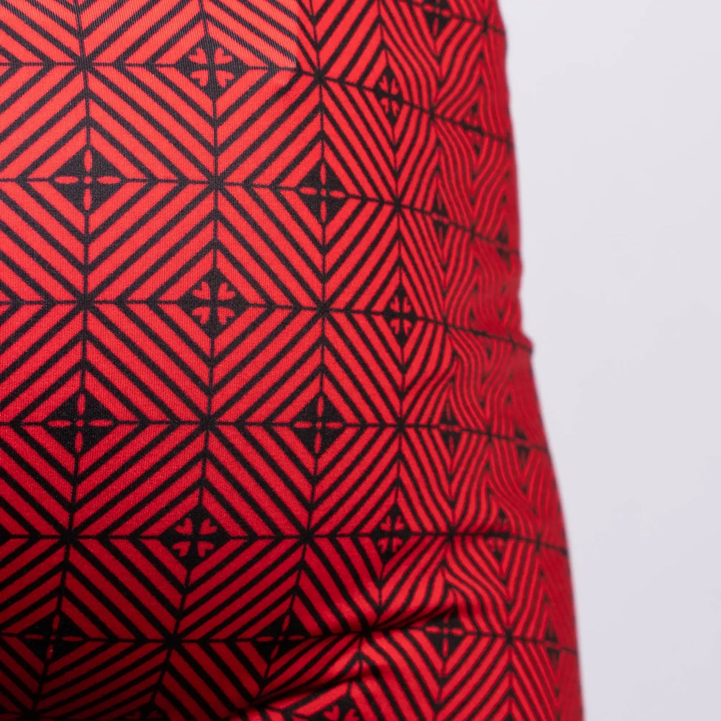 Red fabric of the Kaleidoscope sq cut trunk with a bold black geometric pattern of interlocking diamonds and cross motifs