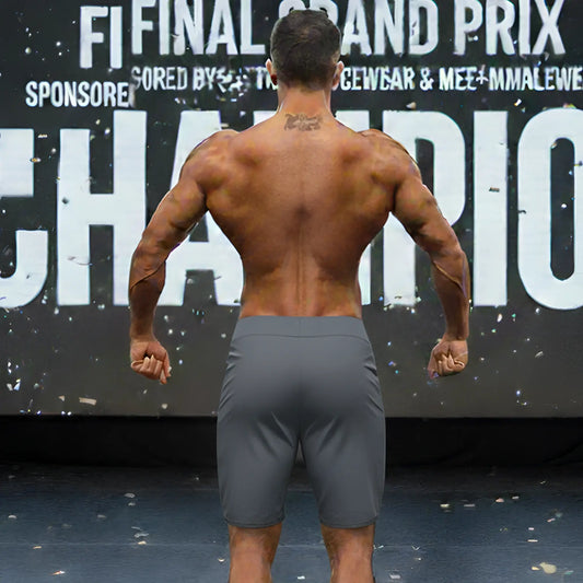 Gray athletic metromusclewear insignia physique board shorts worn by muscular man in charcoal color