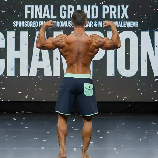 A muscular man wearing navy blue board shorts with a light green waistband and pocket.