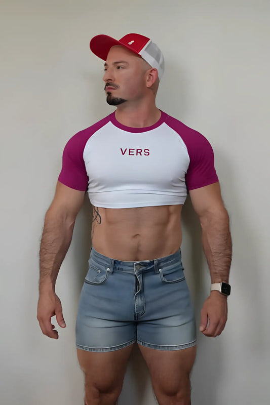 A man wearing a white and magenta muscle-fit raglan crop tee with vers printed in maroon across the chest